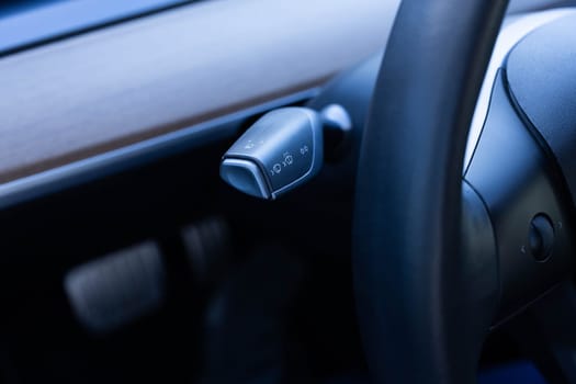 Detail of turning signal, headlights controller in modern car. Multifunction Headlight Console Control Switch knob of electric car. Handle with buttons windshield wiper, turn signal, and washer in car