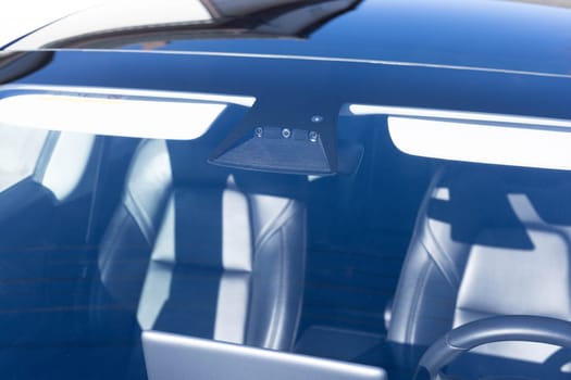 Rain and light sensor on the windshield of the car. Close up view of modern driver assistance. Car System Intelligence - Surround View 360 Degrees Bird Eye View, Line Assist, Front Camera.