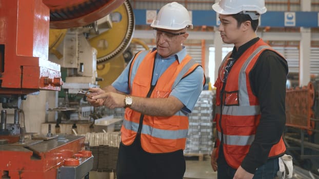 Two engineers talking together in roof steel metal manufacturing factory industry, engineering worker man standing explaining for maintain of metal sheet stamping machine, teamwork concept