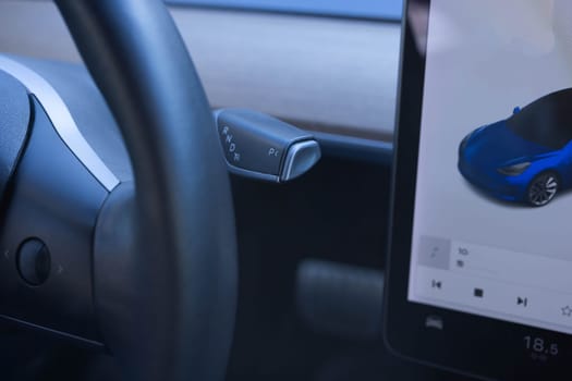 Handle of electric car gearbox control. Design details of minimalist concept of electric car. Close-up of details of automatic transmission and gear stick. Automatic gear lever and gear shift.