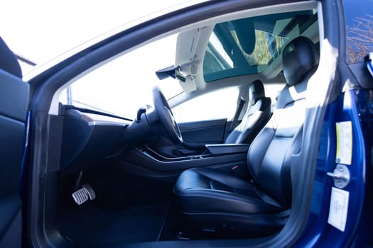 Electric car interior luxury inside. Steering wheel, dashboard, speedometer, display. Blackleather interior. Modern luxury car Interior - steering wheel, shift lever and dashboard.