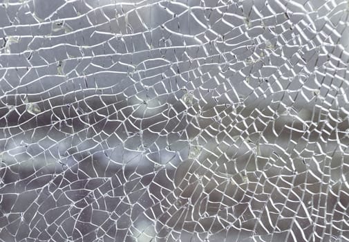 Newcastle, UK - Apr 11, 2025 - Cracks on the glass surface background. Texture of broken tempered glass pane too many small irregular shape pieces holding together. Detail of cracked broken glass cracked by impact, use it as your Wallpaper, Poster and Space for text, Selective focus.