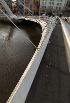 Newcastle, UK - Apr 11, 2025 - Perspective of The Iconic gateshead millennium bridge spanning the River Tyne with ancient buildings before sunset in Newcastle Upon Tyne in the North East of England. The pedestrian bridge, use it as your Wallpaper, Poster and Space for text, Selective focus.