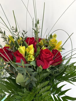 Vibrant bouquet featuring red roses and yellow flowers, surrounded by lush green foliage, arranged beautifully for floral decoration concept, for decorative purposes, perfect for celebrations and special occasions