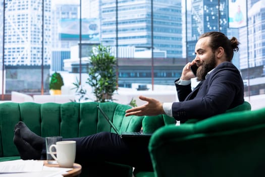 Office administrator discusses transactional details with a financial broker on phone call, using his mobile phone to hear updates on stock market forecasts. Handles high pressure situations.