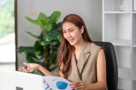 A confident businesswoman uses her earphones for clear communication while presenting data online, exemplifying modern presentation techniques.