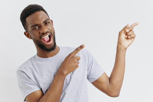 Confident young african american man in casual attire smiling and pointing forward, suggesting direction or making a recommendation.