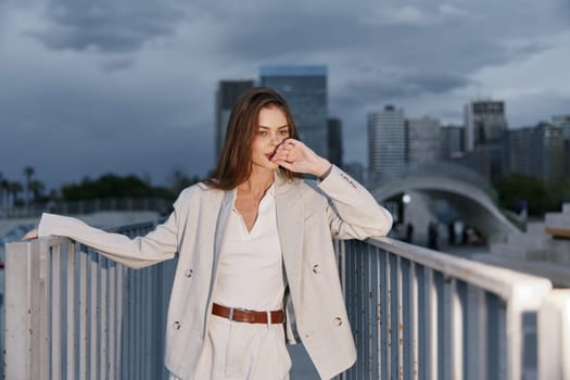 A stylish businesswoman stands confidently in a contemporary urban setting, wearing a chic outfit that reflects professionalism. The moody sky adds a dramatic effect to her determination and style.