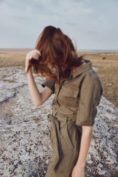 Woman standing on rocky field in the middle of nature beauty and solitude nature adventure trip exploration concept