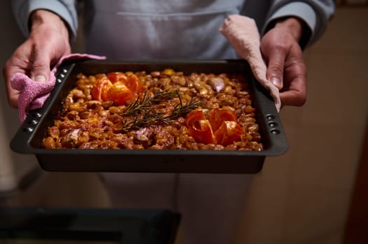 A close-up of a mouthwatering tray of baked beans just out of the oven, garnished with fresh rosemary and baked tomatoes. The vibrant tones highlight the dish's irresistible aroma.