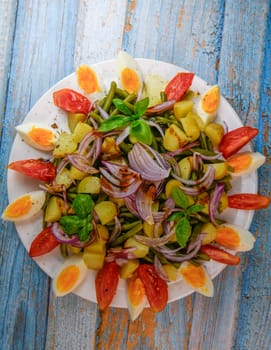 Fresh salad, green beans, small potatoes, egg, tomato, basil, red onions and balsamic vinaigrette. High quality photo