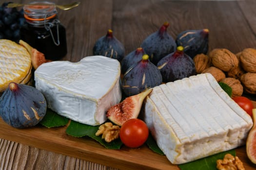 Selection of French cheeses from Normandy, AOP, Livarot, Neufchatel, Pont l'eveque, Rye bread, figs, walnuts, grapes, elderberry gelee. High quality photo