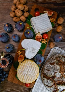 Selection of French cheeses from Normandy, AOP, Livarot, Neufchatel, Pont l'eveque, Rye bread, figs, walnuts, grapes, elderberry gelee. High quality photo