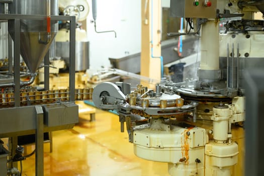 Modern industrial machinery in operation, filling and sealing cans with food product.