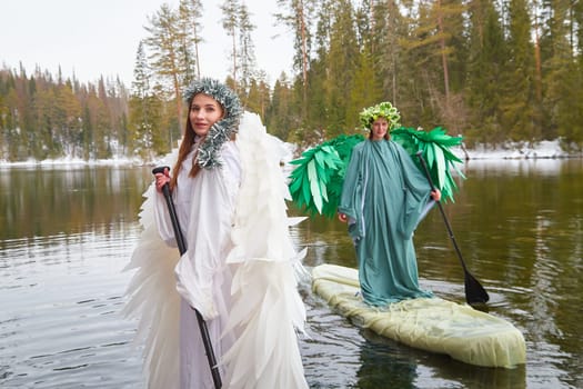 Girls dressed in white and green grace the lake, capturing the magical transition between winter and spring in their whimsical role-playing.