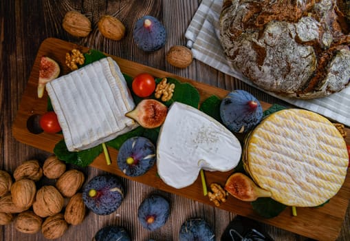 Selection of French cheeses from Normandy, AOP, Livarot, Neufchatel, Pont l'eveque, Rye bread, figs, walnuts, grapes, elderberry gelee. High quality photo