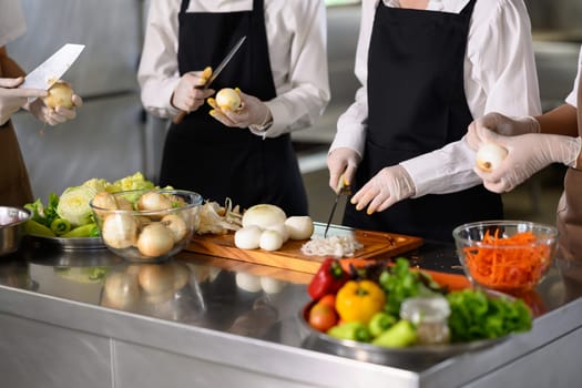 Students peeling and slicing onions during a hands-on culinary training session.