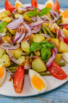 Fresh salad, green beans, small potatoes, egg, tomato, basil, red onions and balsamic vinaigrette. High quality photo