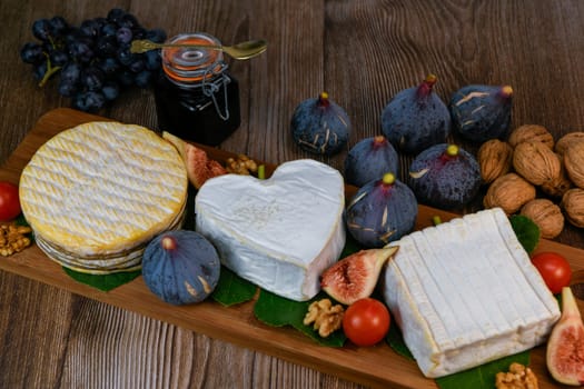 Selection of French cheeses from Normandy, AOP, Livarot, Neufchatel, Pont l'eveque, Rye bread, figs, walnuts, grapes, elderberry gelee. High quality photo