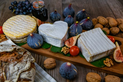 Selection of French cheeses from Normandy, AOP, Livarot, Neufchatel, Pont l'eveque, Rye bread, figs, walnuts, grapes, elderberry gelee. High quality photo