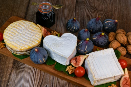 Selection of French cheeses from Normandy, AOP, Livarot, Neufchatel, Pont l'eveque, Rye bread, figs, walnuts, grapes, elderberry gelee. High quality photo