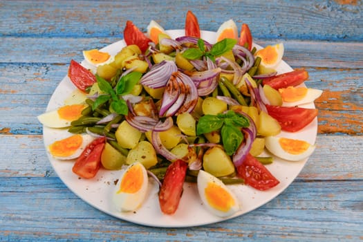 Fresh salad, green beans, small potatoes, egg, tomato, basil, red onions and balsamic vinaigrette. High quality photo