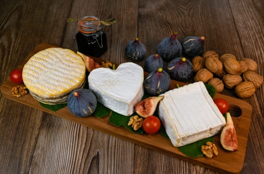 Selection of French cheeses from Normandy, AOP, Livarot, Neufchatel, Pont l'eveque, Rye bread, figs, walnuts, grapes, elderberry gelee. High quality photo
