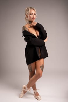 Stylish blonde tattowed woman in black cloth