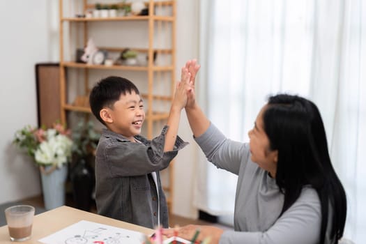 A mother and her son celebrate a successful school preparation with high-fives, showcasing the fun and excitement of getting ready for school.