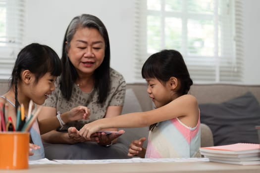 In a cozy home setting, a grandmother assists her granddaughters with handson learning activities, fostering a love for education and creativity.