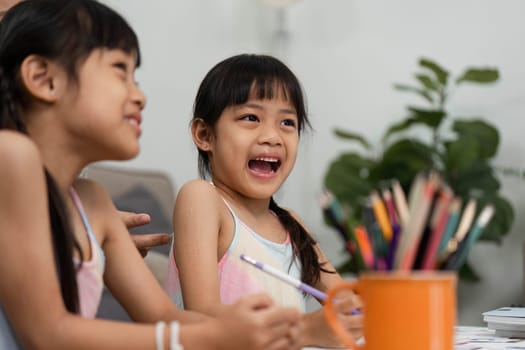 Two young girls engage in a fun art session, showcasing their creativity and joy while drawing and coloring together. Their playful expressions highlight the excitement of back-to-school activities.