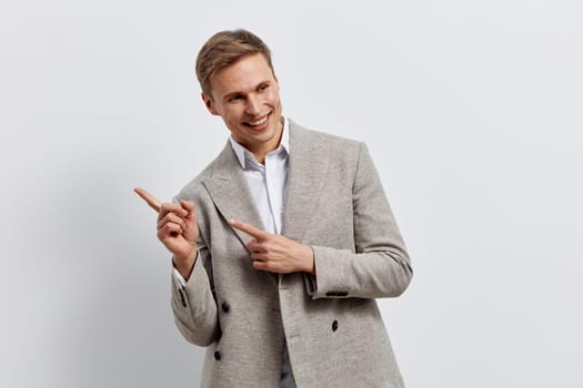 Smiling man wearing casual jacket pointing fingers sideways showing positive emotion and enthusiasm in a bright studio setting. He represents creativity and engagement with digital content generation and AI technology. Concept: generation of content by neural networks.