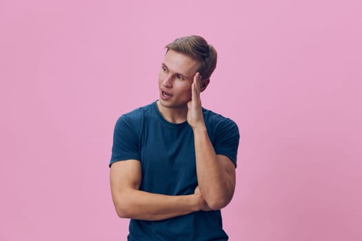 Young thoughtful man wear blue t-shirt look side hold head stressed confused isolated on pink background. Digital detox concept, mental health, mindful break, casual style, studio portrait.