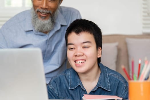 A joyful interaction between a grandfather and his grandchild as they explore educational content together on a laptop, showcasing a loving relationship.