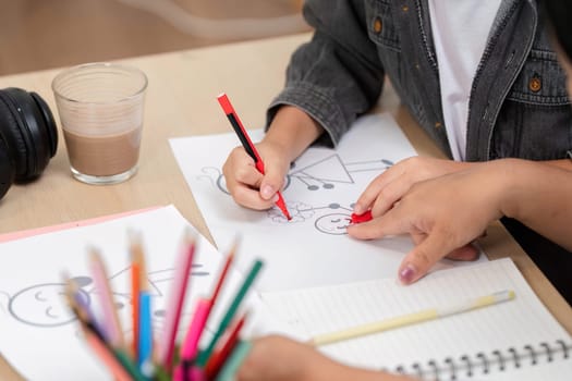 A young artist engages in drawing, using colorful pencils to create imaginative artwork. This moment captures the essence of creativity and learning in a fun environment.