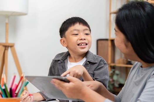 A joyful child shares a moment with their parent while using a tablet, highlighting the importance of interactive learning and family engagement.