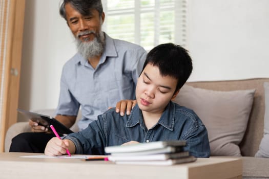 In a nurturing environment, a grandfather guides his grandson through educational activities, emphasizing the importance of support and engagement in learning.