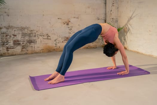 A woman demonstrates her impressive yoga flexibility and skills in a stylish and inviting indoor setting