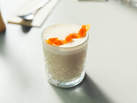 Refreshing citrus cocktail on a white table. Handcrafted beverages and stylish cafe culture concept.
