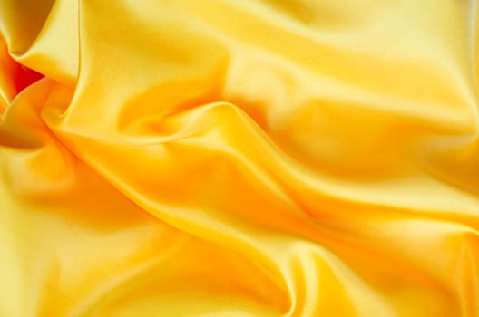 Top view of bright yellow satin fabric with a glossy finish. Suitable for design and wallpaper background.
