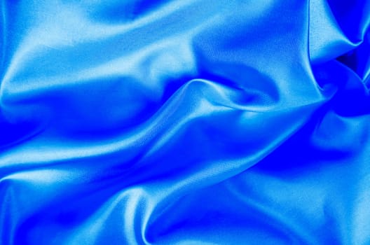 Light blue color silk in soft, smooth waves with a glossy finish. Suitable for design and wallpaper background.