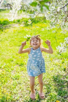 Child in a garden of flowering trees. Selective focus. kid.