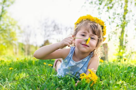 Child in the garden with a bouquet of dandelions. Selective focus. Kid.