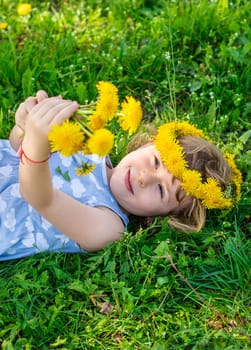 Child in the garden with a bouquet of dandelions. Selective focus. Kid.