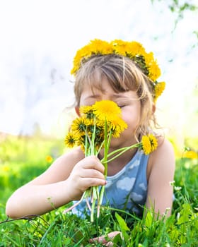 Child in the garden with a bouquet of dandelions. Selective focus. Kid.