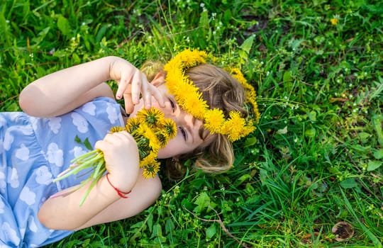 Child in the garden with a bouquet of dandelions. Selective focus. Kid.