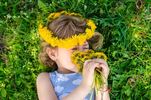 Child in the garden with a bouquet of dandelions. Selective focus. Kid.