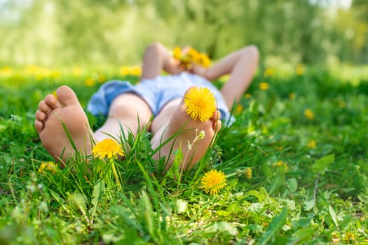 child feet in a garden with dandelions. Selective focus. kid,