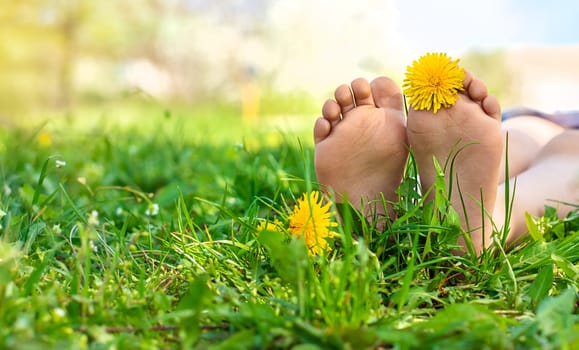 child feet in a garden with dandelions. Selective focus. kid,