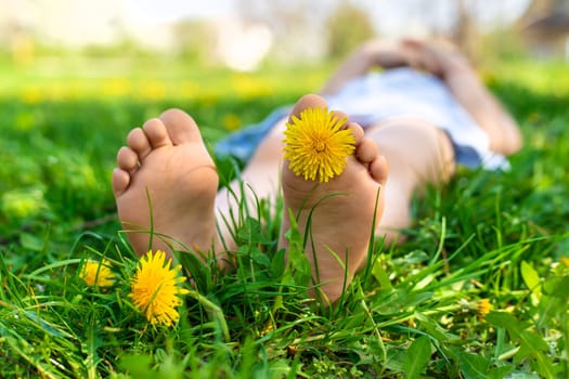 child feet in a garden with dandelions. Selective focus. kid,